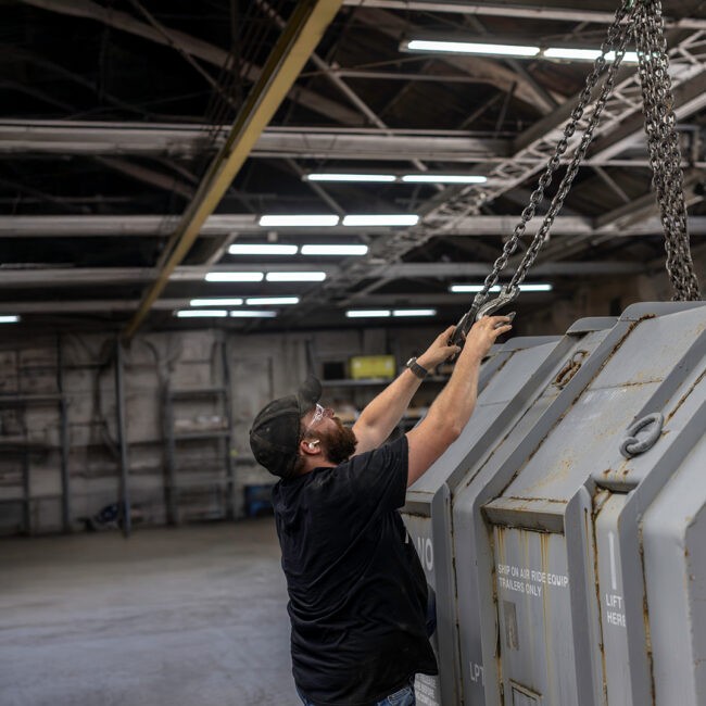 Worker helping loading a LM2500 container