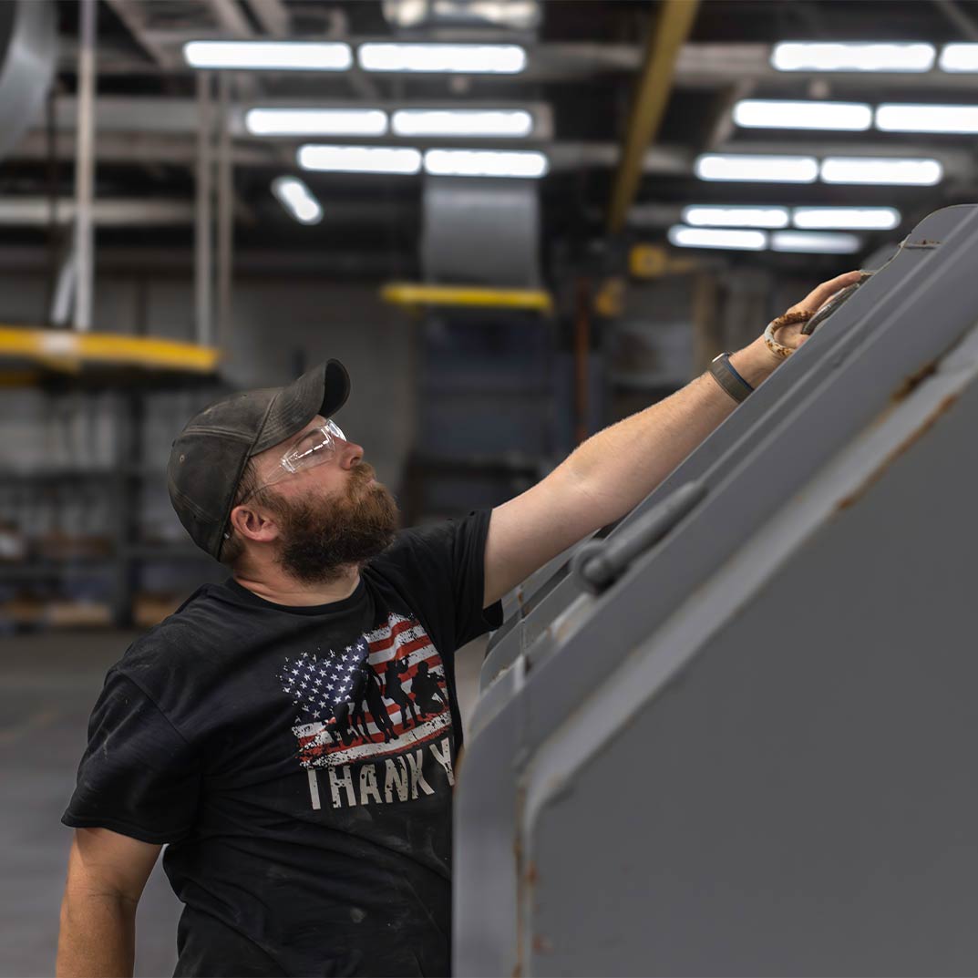 Worker at The Champion GSE touching a LM2500 container