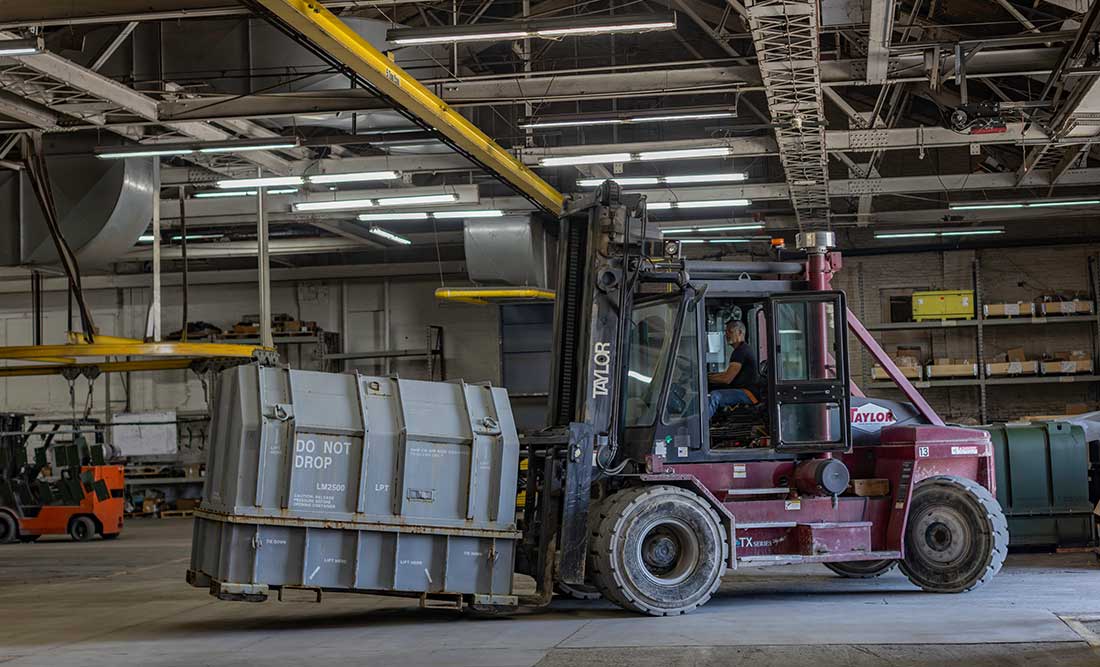 Worker in a truck moving a LM2500 container at The Champion GSE's warehouse